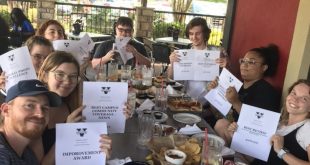 The Spectator staff holds printed copies of their awards